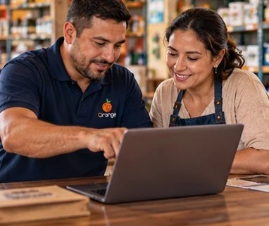 Dos personas, una del equipo de Orange, revisan juntas el sistema en un portátil